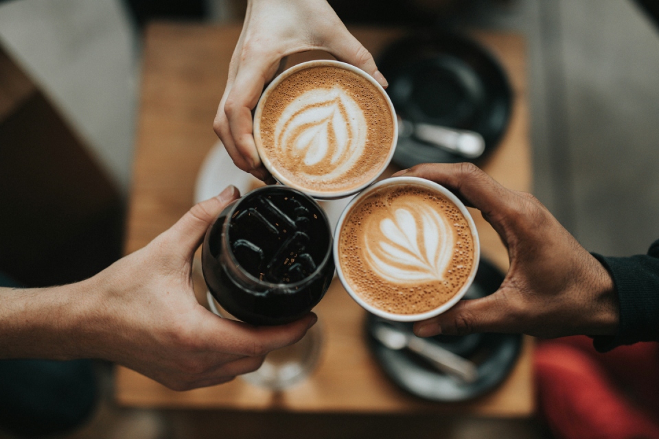 Friends toasting with different coffee drinks