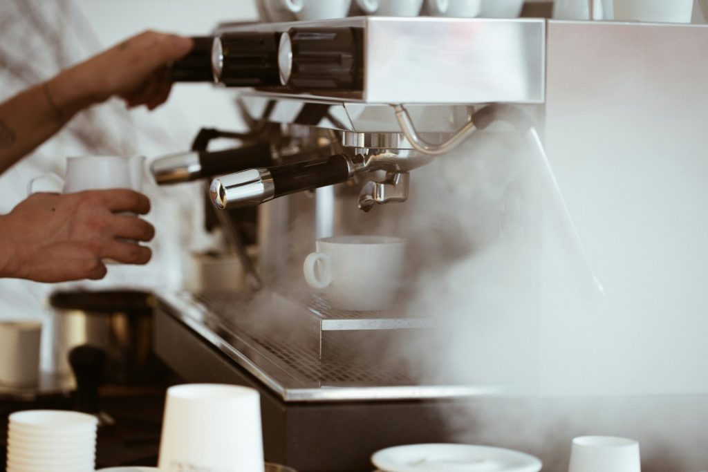 Steaming espresso machine in busy café